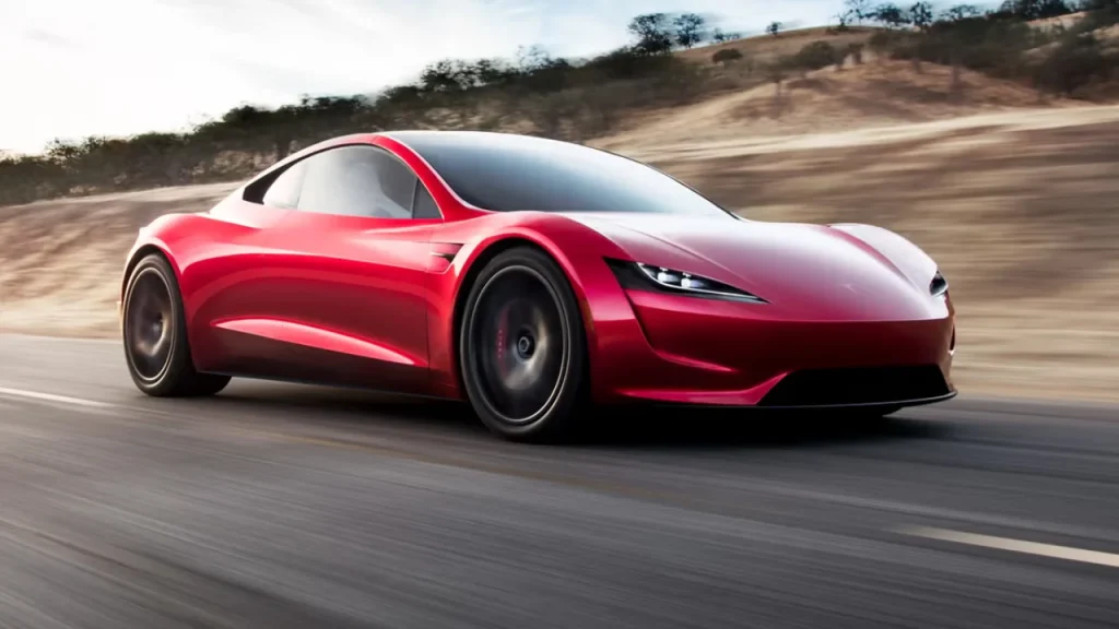A striking red Tesla electric sports car cruising fast down a desert highway, epitomizing popularity within the Best EV brands.
